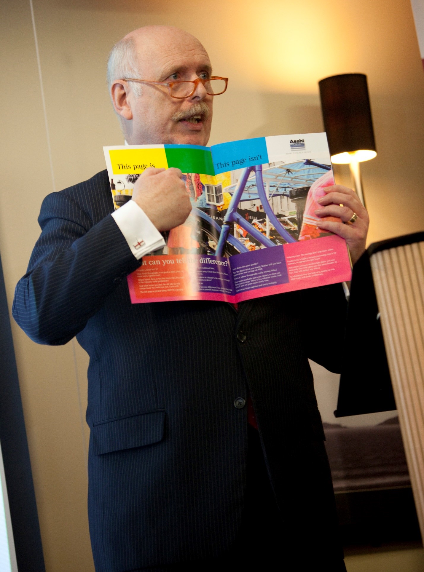 Dr. David Galton explaining/presenting an flexographic magazine (very colourful)